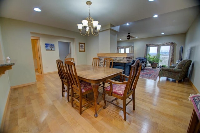 dining space with recessed lighting, ceiling fan with notable chandelier, light wood-type flooring, and baseboards