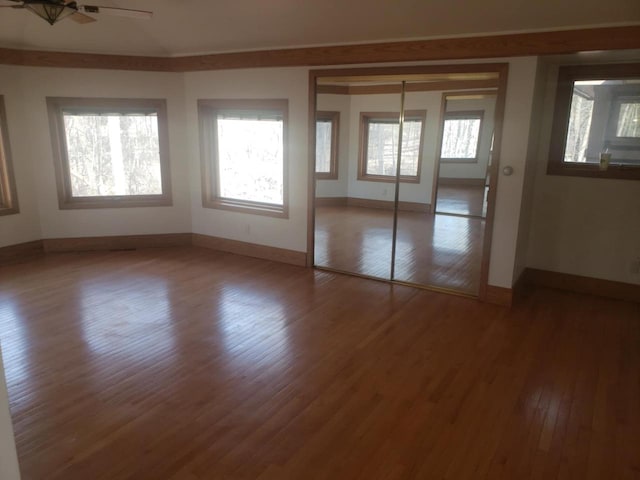 interior space featuring ceiling fan, baseboards, and wood finished floors