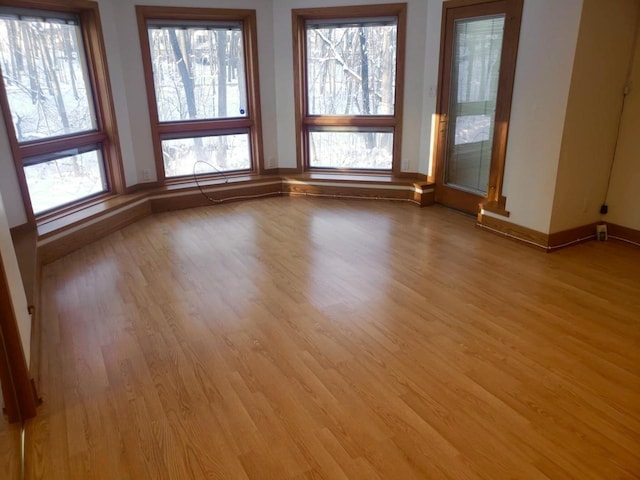 empty room featuring light wood finished floors and baseboards