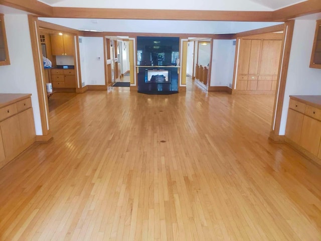 unfurnished living room featuring light wood-style flooring, a fireplace, and baseboards