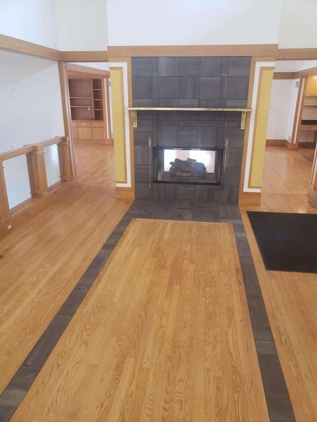 details featuring built in shelves, wood finished floors, and a tile fireplace