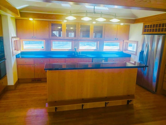 kitchen with stainless steel fridge, visible vents, light wood-style flooring, and a sink