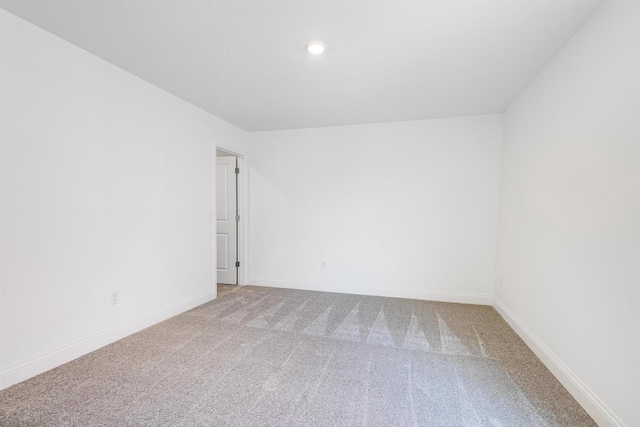 carpeted spare room featuring baseboards