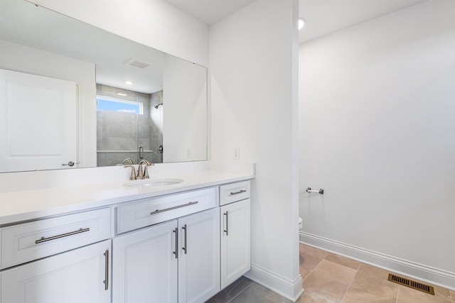 bathroom featuring visible vents, baseboards, toilet, a stall shower, and vanity