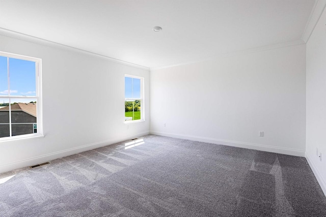 carpeted empty room featuring baseboards, visible vents, and ornamental molding