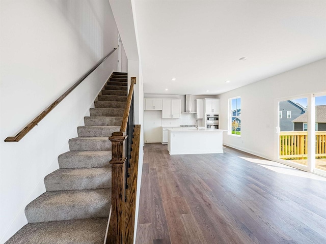 stairs with recessed lighting, baseboards, plenty of natural light, and wood finished floors