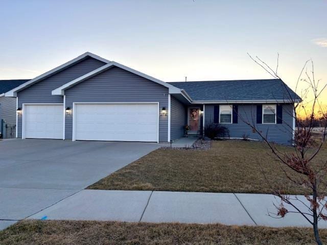 single story home featuring driveway, a front lawn, and a garage