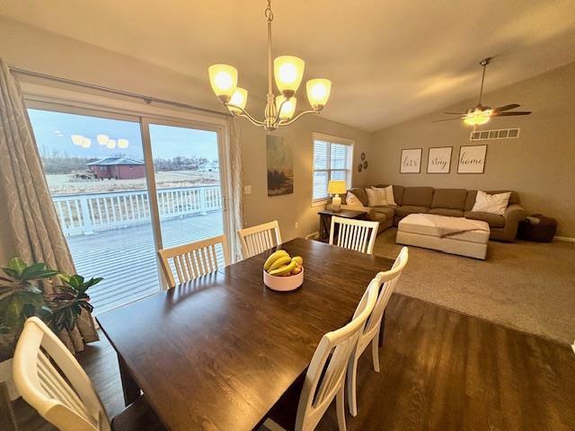 dining area with visible vents, lofted ceiling, and ceiling fan with notable chandelier