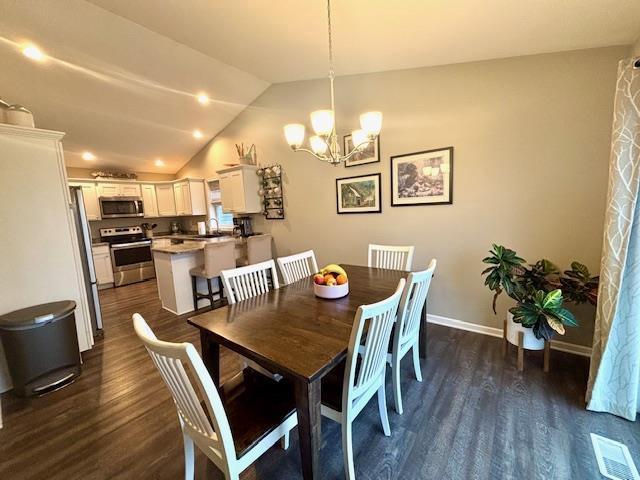 dining space with a notable chandelier, visible vents, lofted ceiling, and dark wood-style flooring