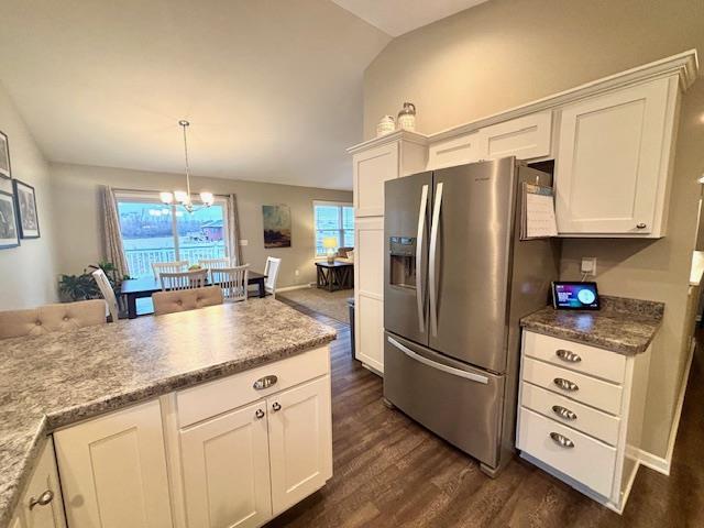 kitchen featuring dark wood-style floors, stainless steel fridge, lofted ceiling, and white cabinets