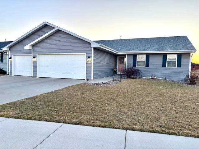 ranch-style home with driveway, a front yard, a garage, and a shingled roof