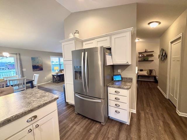 kitchen with baseboards, lofted ceiling, dark wood-style flooring, white cabinetry, and stainless steel fridge