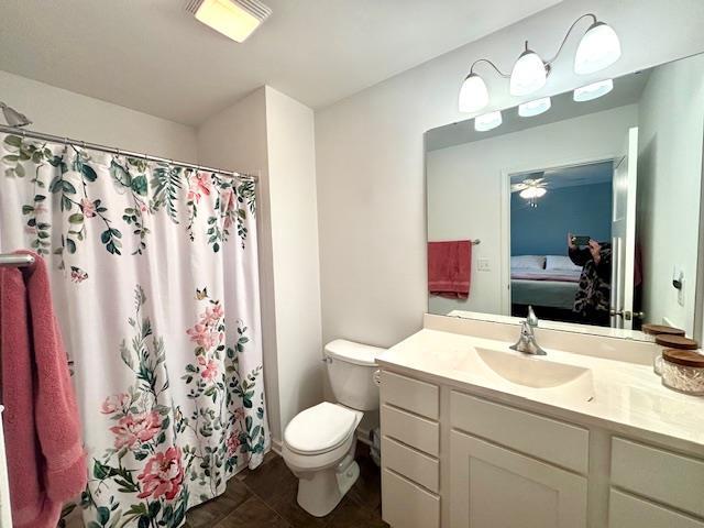 ensuite bathroom with vanity, a shower with shower curtain, visible vents, ensuite bath, and toilet