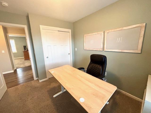 home office featuring dark colored carpet and baseboards