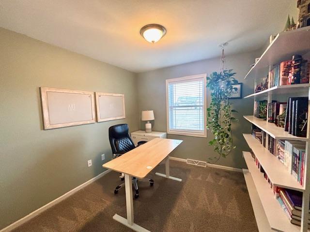 carpeted office space with visible vents and baseboards