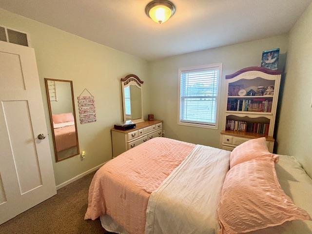 bedroom with visible vents, baseboards, and dark colored carpet