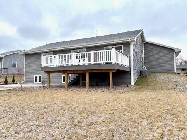 back of property with a deck, stairway, and central AC