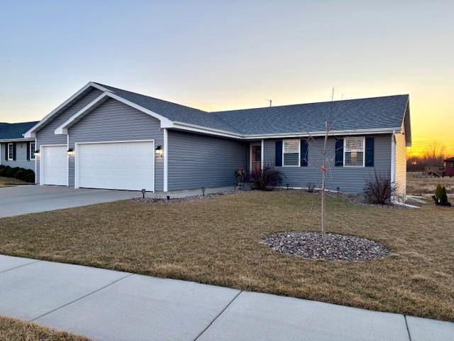 single story home featuring concrete driveway, a lawn, a garage, and roof with shingles