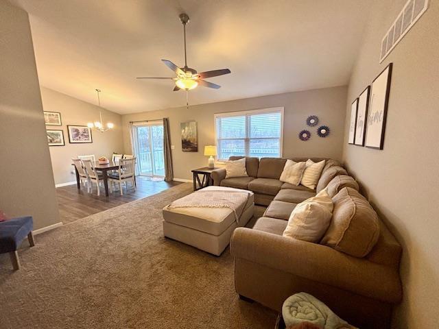 carpeted living room with visible vents, a healthy amount of sunlight, ceiling fan with notable chandelier, and vaulted ceiling