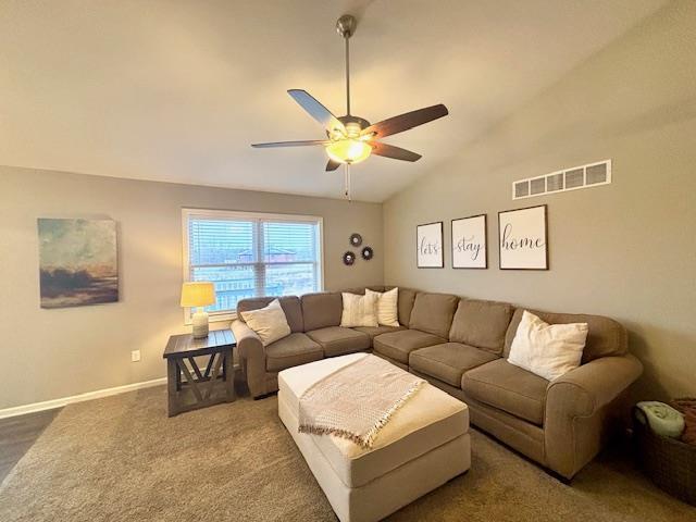 carpeted living room featuring lofted ceiling, a ceiling fan, visible vents, and baseboards