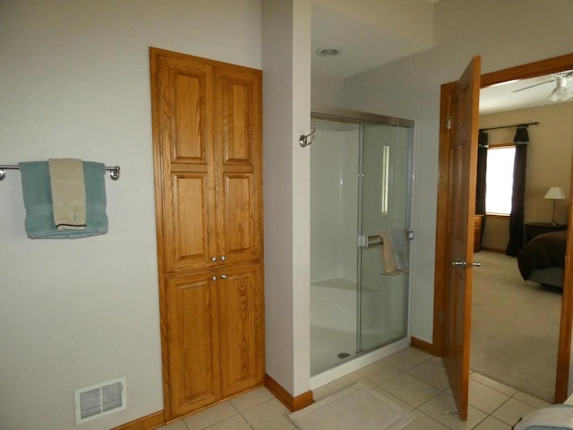 ensuite bathroom featuring tile patterned flooring, a shower stall, visible vents, and connected bathroom