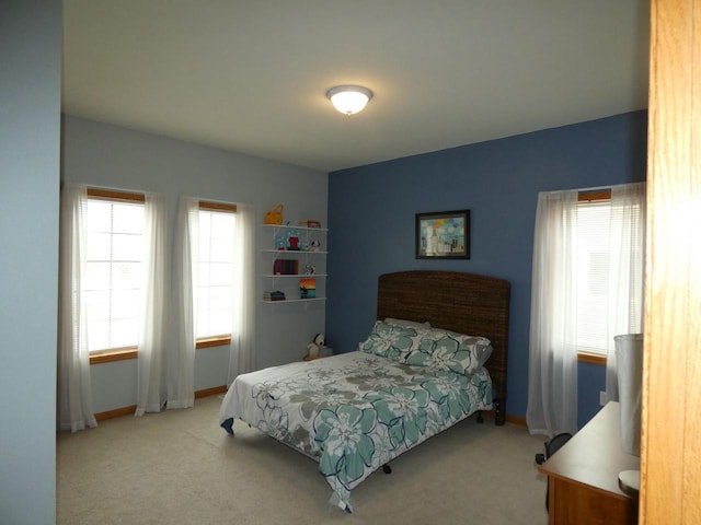 bedroom featuring baseboards and light carpet