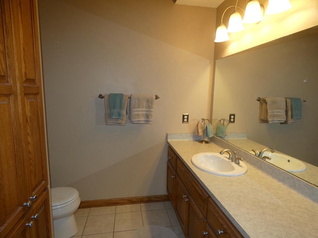 bathroom with baseboards, toilet, vanity, and tile patterned flooring