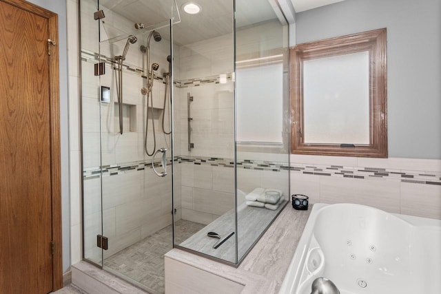 full bath featuring a jetted tub and a stall shower