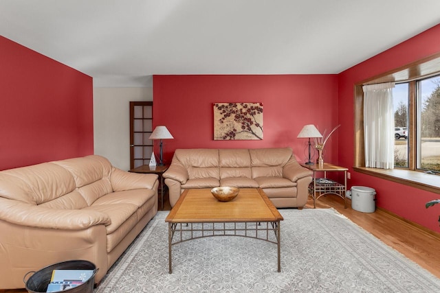 living room featuring wood finished floors and an accent wall