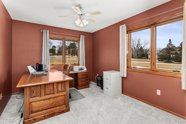 office space with light colored carpet, baseboards, and a ceiling fan