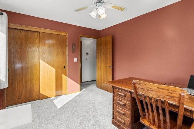 carpeted office with a ceiling fan