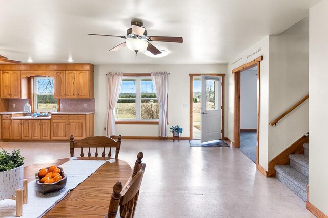 N402 24th Ave, Neshkoro, WI 54960 - dining room with baseboards, a healthy amount of sunlight, stairway, and ceiling fan
