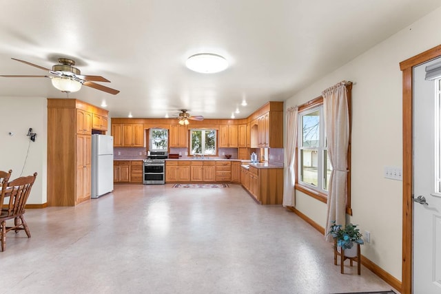 N402 24th Ave, Neshkoro, WI 54960 - kitchen featuring baseboards, ceiling fan, range with two ovens, a wealth of natural light, and freestanding refrigerator