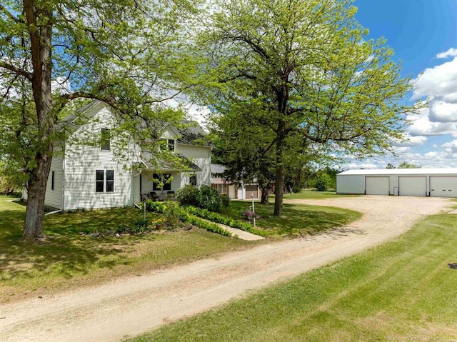 N402 24th Ave, Neshkoro, WI 54960 - view of front of house with driveway, a detached garage, a front lawn, and an outbuilding