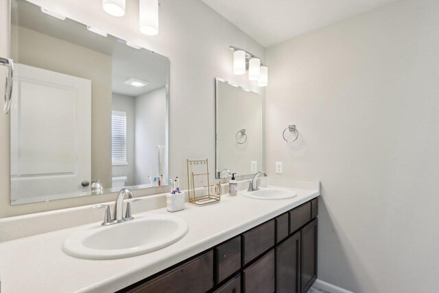 6109 Misty Bridge Rd, Madison, WI 53718 - full bath with a sink, baseboards, toilet, and double vanity