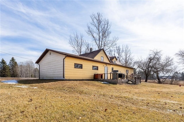 back of house featuring a wooden deck and a lawn