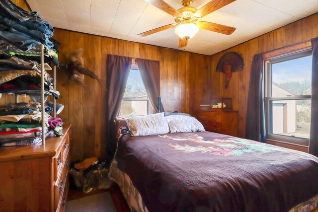 523 State Highway 73, Nekoosa, WI 54457 - bedroom featuring multiple windows, a ceiling fan, and wood walls