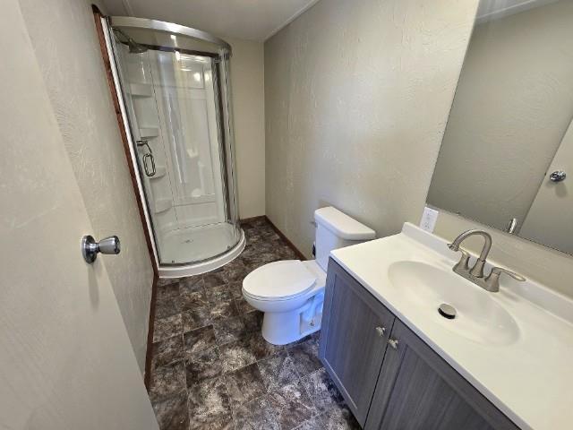 W5029 N Pathfinder Cir, Shawano, WI 54166 - bathroom featuring toilet, stone finish floor, a shower stall, vanity, and a textured wall