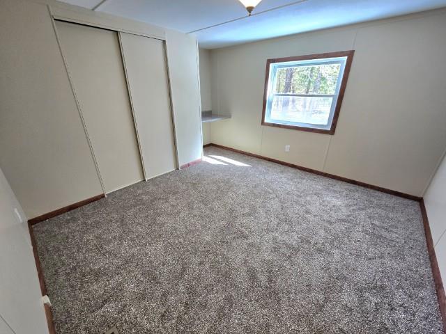 W5029 N Pathfinder Cir, Shawano, WI 54166 - unfurnished bedroom featuring a closet and carpet floors
