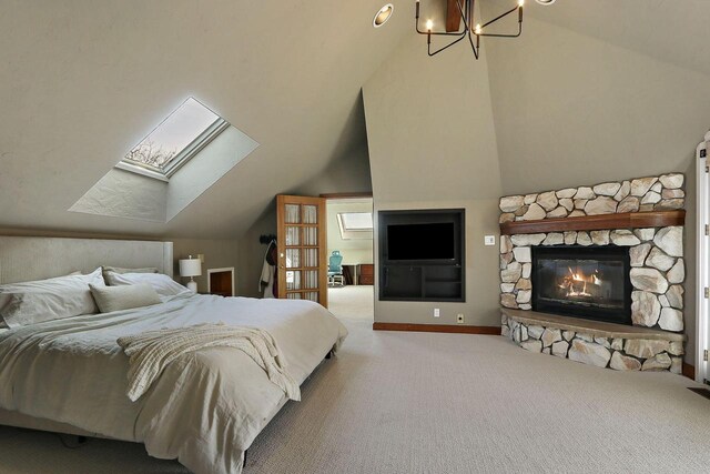 2842 Moelter Dr, Lake Geneva, WI 53147 - carpeted bedroom with a chandelier, a stone fireplace, lofted ceiling with skylight, and baseboards