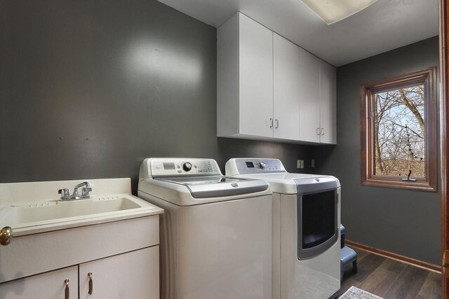 2842 Moelter Dr, Lake Geneva, WI 53147 - laundry area featuring washer and dryer, a sink, dark wood finished floors, cabinet space, and baseboards