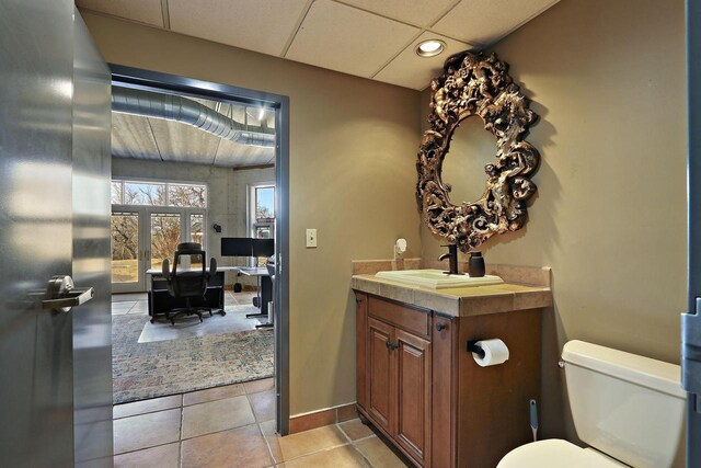2842 Moelter Dr, Lake Geneva, WI 53147 - bathroom featuring tile patterned flooring, baseboards, a drop ceiling, toilet, and vanity