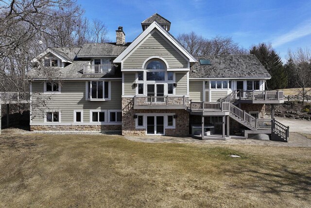 2842 Moelter Dr, Lake Geneva, WI 53147 - back of property with a balcony, a chimney, stairs, stone siding, and a lawn