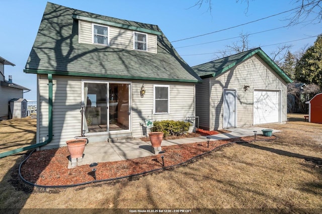rear view of property featuring a patio and a garage