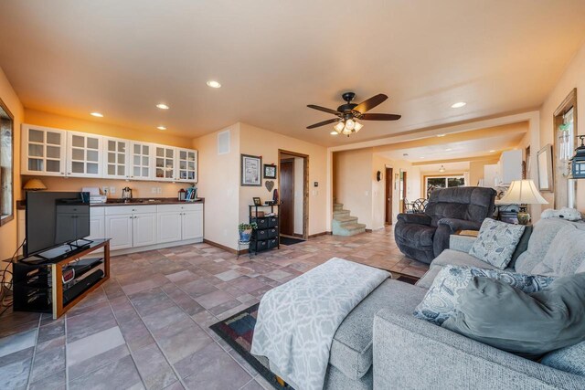 living area featuring visible vents, a ceiling fan, recessed lighting, baseboards, and stairs