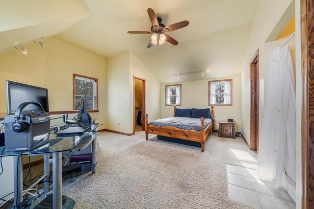 bedroom with baseboards, light carpet, track lighting, and vaulted ceiling
