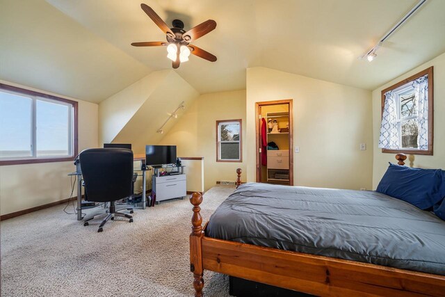 carpeted bedroom featuring baseboards, multiple windows, ceiling fan, and vaulted ceiling