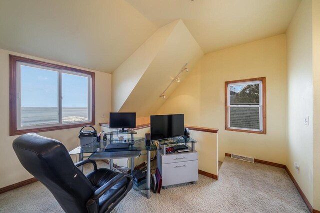 home office featuring baseboards, visible vents, lofted ceiling, and light carpet