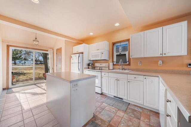kitchen featuring white appliances, white cabinets, recessed lighting, and a sink