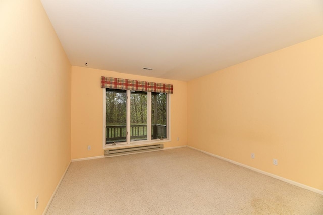 carpeted spare room featuring visible vents, a baseboard heating unit, and baseboards